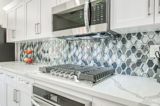 3081 Serena Ave, Clovis, CA 93619 - kitchen with stainless steel appliances, white cabinetry, backsplash, and light stone counters