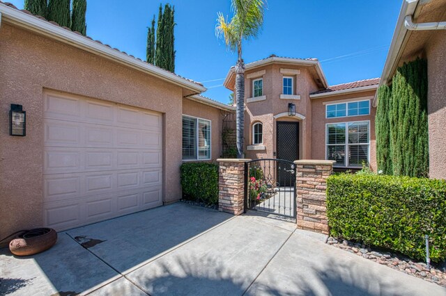 3081 Serena Ave, Clovis, CA 93619 - view of front of home featuring stucco siding, a gate, an attached garage, a tiled roof, and concrete driveway