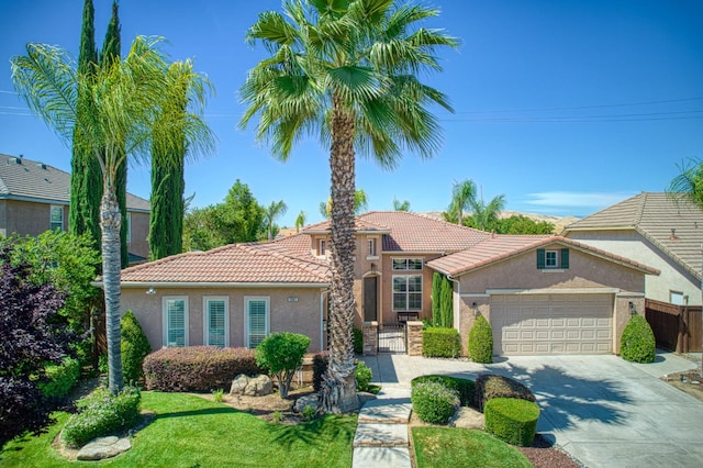 3081 Serena Ave, Clovis, CA 93619 - mediterranean / spanish-style home featuring a tile roof, stucco siding, a garage, concrete driveway, and a gate