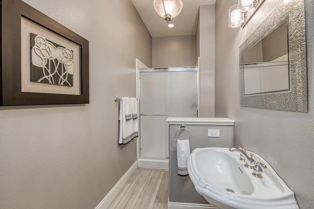 3081 Serena Ave, Clovis, CA 93619 - full bathroom featuring a sink, baseboards, a stall shower, and wood finished floors