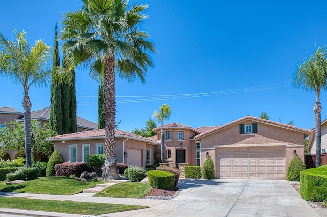 3081 Serena Ave, Clovis, CA 93619 - mediterranean / spanish-style home featuring a garage, stucco siding, concrete driveway, a front lawn, and a tiled roof