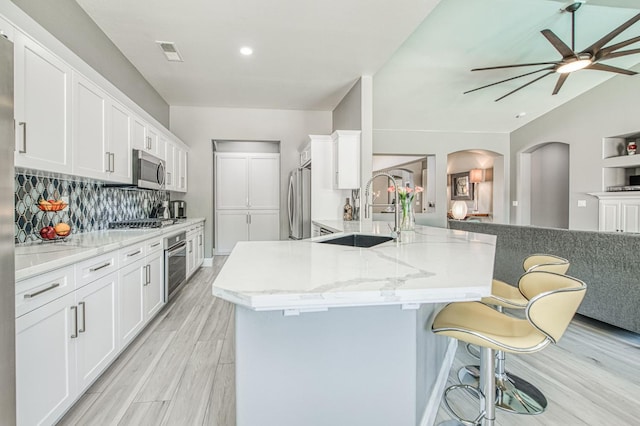 3081 Serena Ave, Clovis, CA 93619 - kitchen with a sink, appliances with stainless steel finishes, arched walkways, a ceiling fan, and white cabinetry