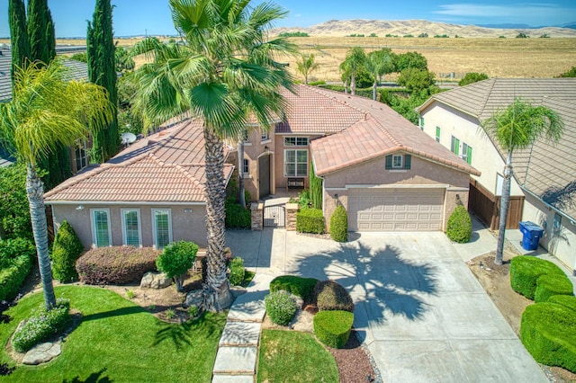 3081 Serena Ave, Clovis, CA 93619 - view of front of house with concrete driveway, a garage, stucco siding, a tile roof, and a mountain view