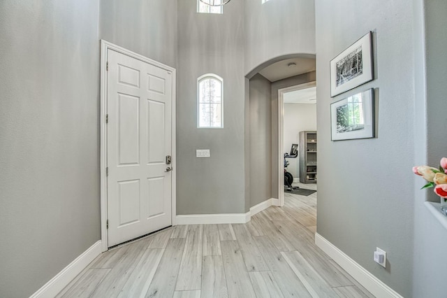 3081 Serena Ave, Clovis, CA 93619 - foyer entrance featuring arched walkways, light wood-style floors, baseboards, and a high ceiling