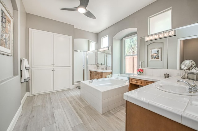 3081 Serena Ave, Clovis, CA 93619 - bathroom with a shower stall, two vanities, a bath, a ceiling fan, and wood finished floors