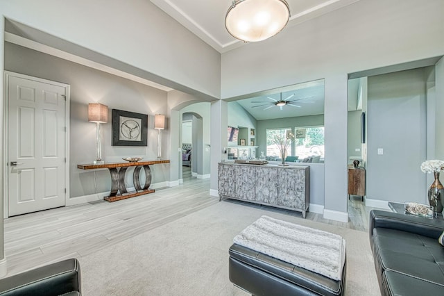3081 Serena Ave, Clovis, CA 93619 - living room with arched walkways, a ceiling fan, baseboards, wood finished floors, and a high ceiling