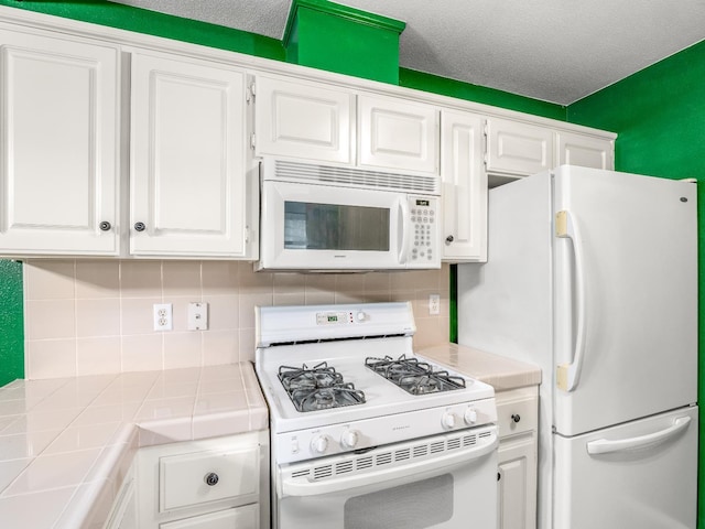 474 E Alluvial Ave Unit 139, Fresno, CA 93720 - kitchen featuring white appliances, tile counters, white cabinets, and tasteful backsplash
