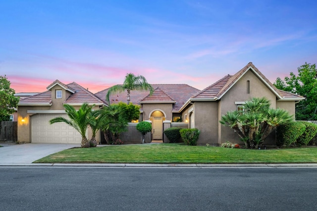 1698 E Wallington Ln, Fresno, CA 93730 - view of front facade featuring an attached garage, concrete driveway, stucco siding, and a tile roof