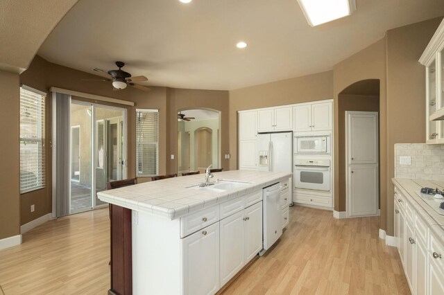 1698 E Wallington Ln, Fresno, CA 93730 - kitchen with white appliances, a sink, ceiling fan, arched walkways, and light wood finished floors