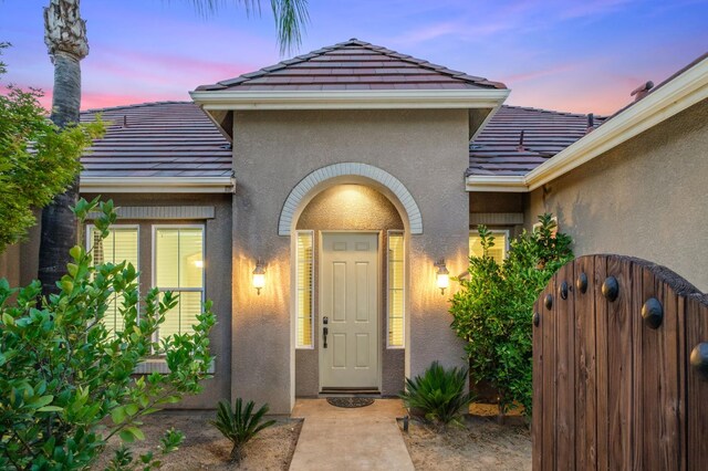 1698 E Wallington Ln, Fresno, CA 93730 - property entrance featuring a tile roof, stucco siding, and a gate
