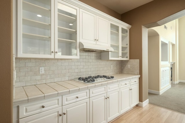 1698 E Wallington Ln, Fresno, CA 93730 - kitchen featuring under cabinet range hood, white gas cooktop, white cabinets, and baseboards