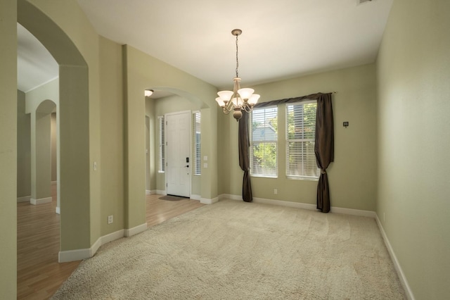 1698 E Wallington Ln, Fresno, CA 93730 - spare room with arched walkways, a chandelier, baseboards, and carpet