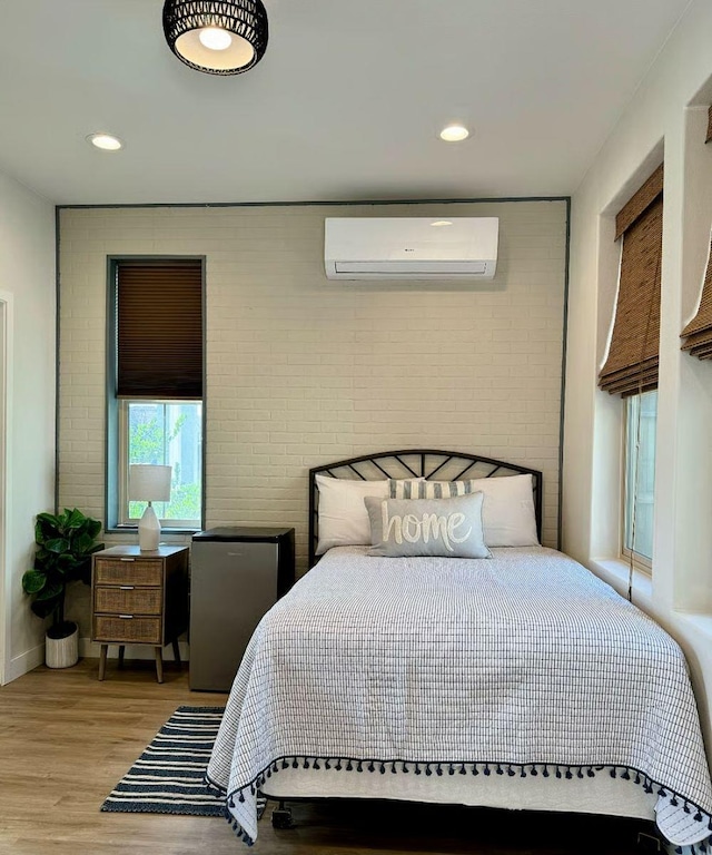 385 Fir St W, Madera, CA 93636 - bedroom featuring an AC wall unit, brick wall, light wood-style floors, and recessed lighting