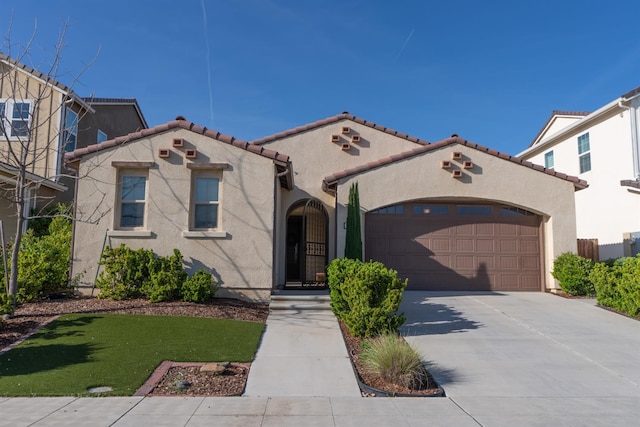 385 Fir St W, Madera, CA 93636 - mediterranean / spanish-style house featuring concrete driveway, a garage, stucco siding, a tiled roof, and a front lawn