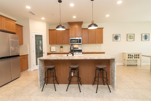 385 Fir St W, Madera, CA 93636 - kitchen featuring appliances with stainless steel finishes, brown cabinets, backsplash, light tile patterned floors, and recessed lighting