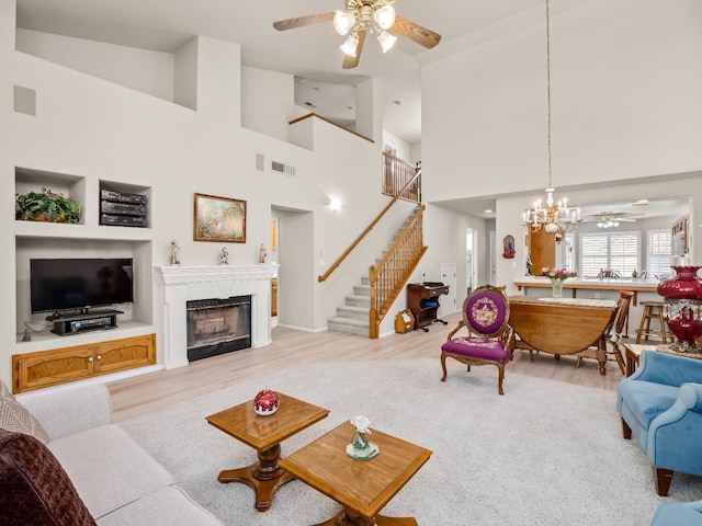 6424 N Allison Ln, Fresno, CA 93711 - living area with a ceiling fan, stairway, a fireplace, a chandelier, and a high ceiling