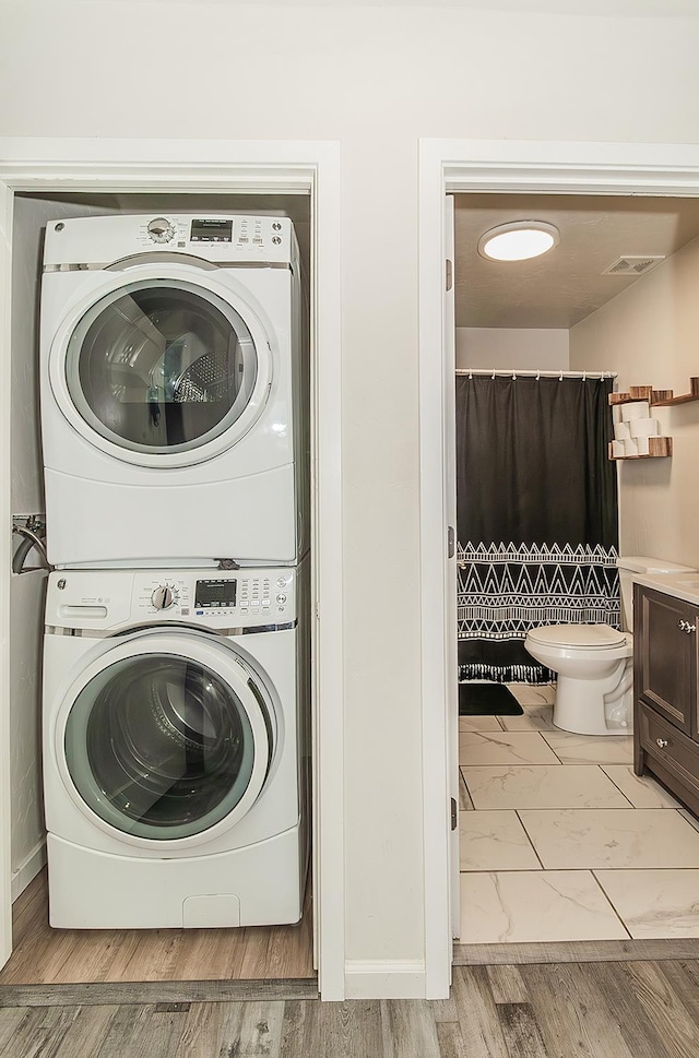 2216 E Floradora Ave, Fresno, CA 93703 - washroom with stacked washing machine and dryer and marble finish floors