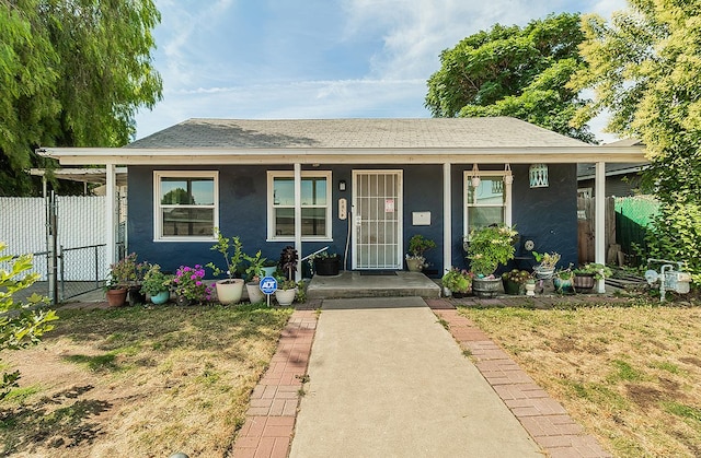 2216 E Floradora Ave, Fresno, CA 93703 - view of front of home with a porch, a shingled roof, a gate, and stucco siding