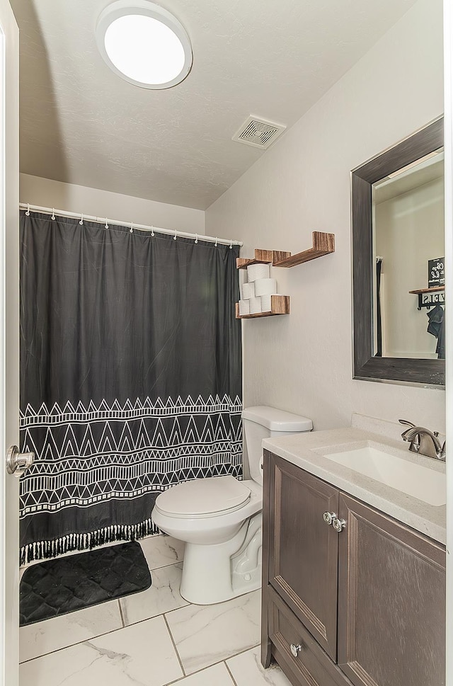 2216 E Floradora Ave, Fresno, CA 93703 - full bathroom with marble look tile flooring, toilet, vanity, and a shower with shower curtain