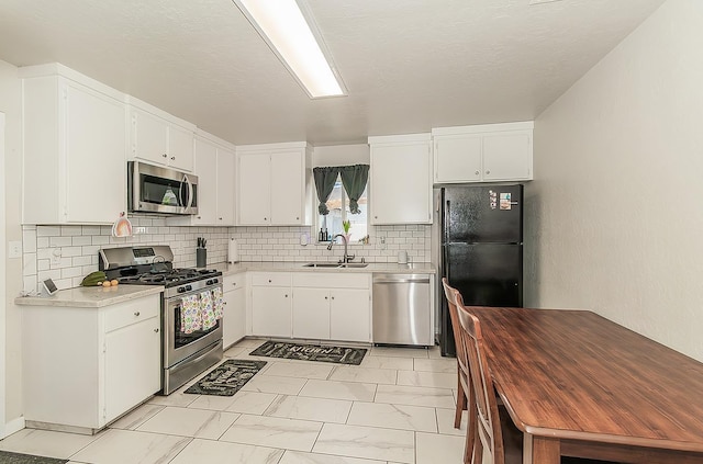 2216 E Floradora Ave, Fresno, CA 93703 - kitchen with appliances with stainless steel finishes, a sink, light marble finish flooring, light countertops, and white cabinetry