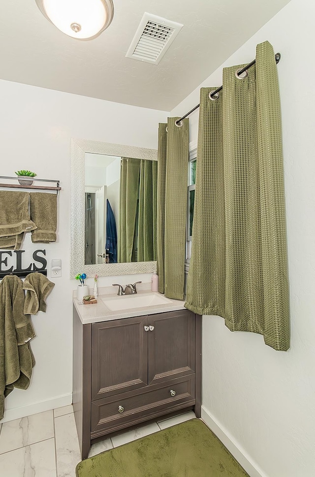 2216 E Floradora Ave, Fresno, CA 93703 - bathroom with baseboards, vanity, and marble finish flooring