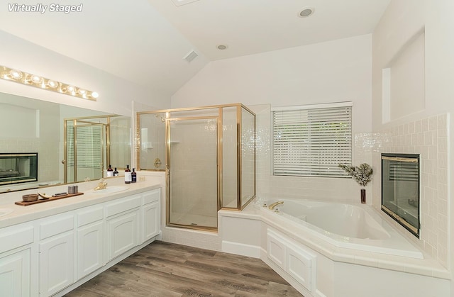 1783 E Pryor Dr, Fresno, CA 93720 - bathroom featuring a tiled fireplace, a garden tub, a shower stall, vanity, and vaulted ceiling