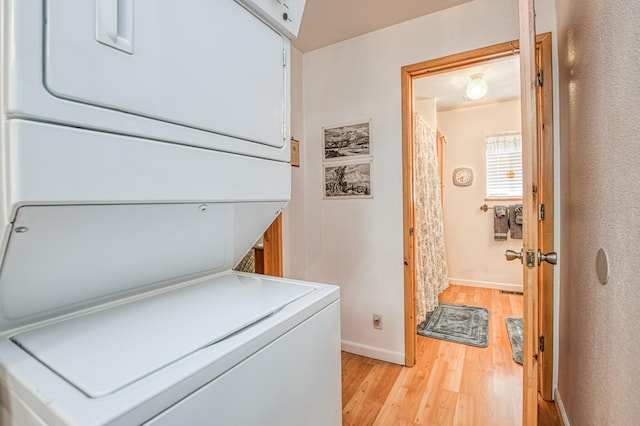 42357 Hanging Branch Rd, Shaver Lake, CA 93664 - laundry area featuring stacked washer / drying machine, light wood-style floors, and baseboards
