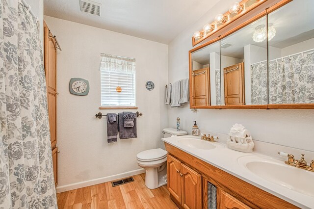 42357 Hanging Branch Rd, Shaver Lake, CA 93664 - bathroom with wood finished floors, double vanity, toilet, baseboards, and a shower with curtain