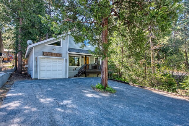 42357 Hanging Branch Rd, Shaver Lake, CA 93664 - view of front facade with asphalt driveway, a garage, covered porch, and stairway