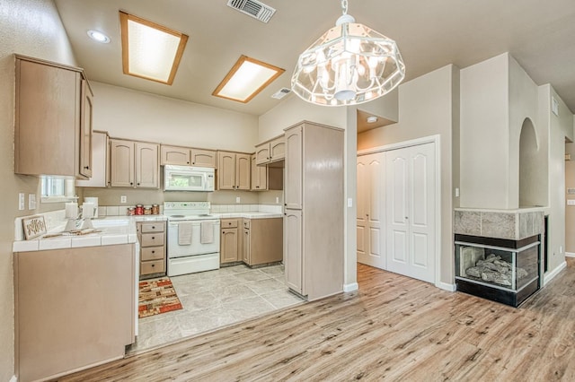 7518 N Trellis Cir, Fresno, CA 93720 - kitchen featuring white appliances, tile countertops, light wood-type flooring, arched walkways, and hanging light fixtures