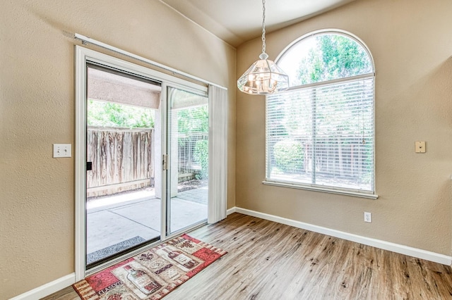 7518 N Trellis Cir, Fresno, CA 93720 - unfurnished dining area with wood finished floors, baseboards, a textured wall, and a chandelier