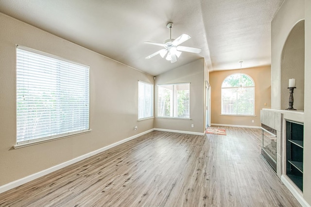 7518 N Trellis Cir, Fresno, CA 93720 - unfurnished living room with wood finished floors, a ceiling fan, vaulted ceiling, baseboards, and arched walkways