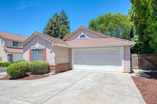 7518 N Trellis Cir, Fresno, CA 93720 - view of front of property with driveway, stucco siding, an attached garage, and a tiled roof