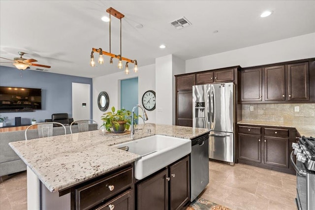3930 Saginaw Ave, Clovis, CA 93619 - kitchen featuring stainless steel appliances, a sink, ceiling fan, open floor plan, and dark brown cabinets