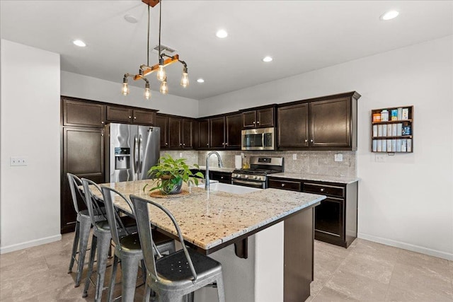 3930 Saginaw Ave, Clovis, CA 93619 - kitchen with appliances with stainless steel finishes, decorative backsplash, baseboards, dark brown cabinets, and light stone counters