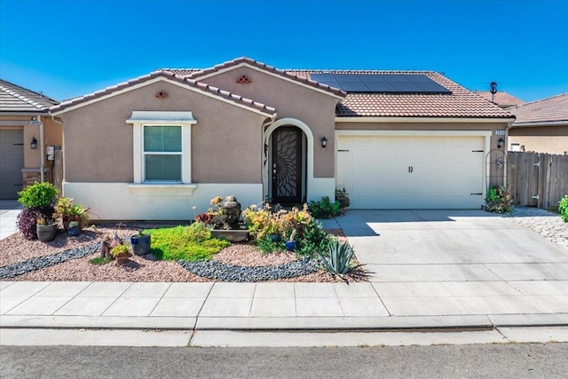 3930 Saginaw Ave, Clovis, CA 93619 - view of front of home featuring a garage, roof mounted solar panels, stucco siding, a tiled roof, and concrete driveway