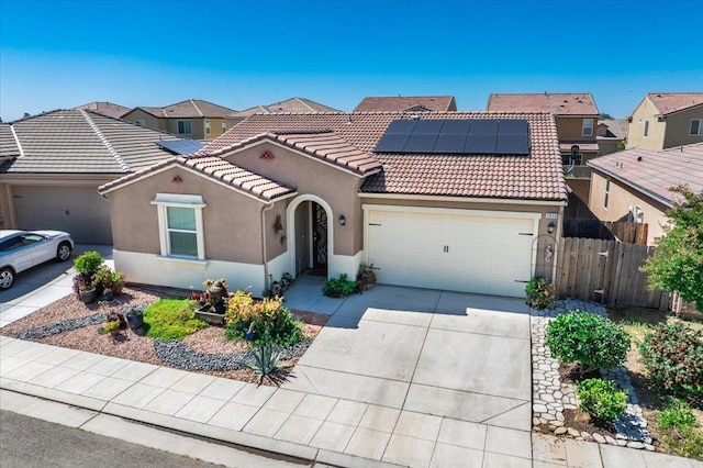 3930 Saginaw Ave, Clovis, CA 93619 - view of front facade featuring an attached garage, stucco siding, roof mounted solar panels, concrete driveway, and a tile roof