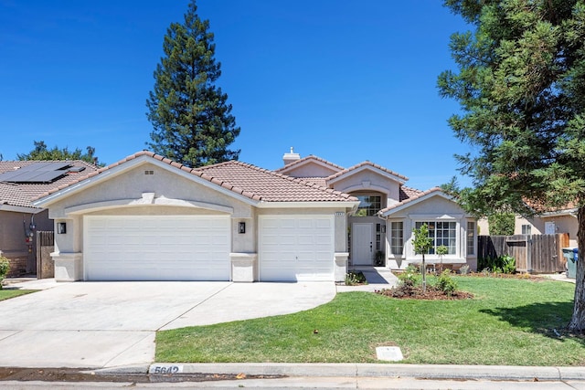5642 W Beechwood Ave, Fresno, CA 93722 - view of front of home with a tiled roof, an attached garage, concrete driveway, stucco siding, and a chimney