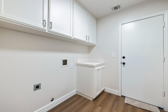 5642 W Beechwood Ave, Fresno, CA 93722 - laundry area with electric dryer hookup, dark wood finished floors, cabinet space, baseboards, and hookup for a washing machine