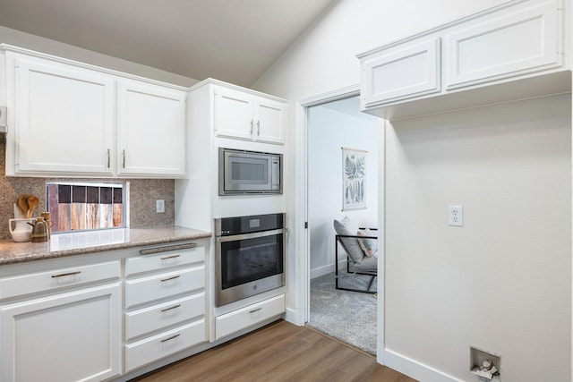 5642 W Beechwood Ave, Fresno, CA 93722 - kitchen with appliances with stainless steel finishes, tasteful backsplash, light wood-type flooring, and white cabinets