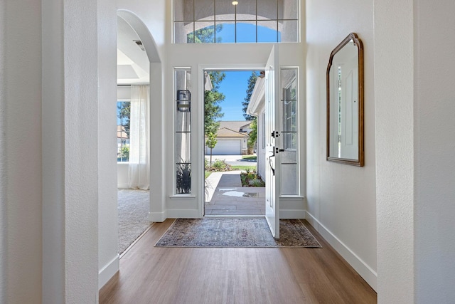 5642 W Beechwood Ave, Fresno, CA 93722 - entryway with wood finished floors, arched walkways, baseboards, and a textured wall