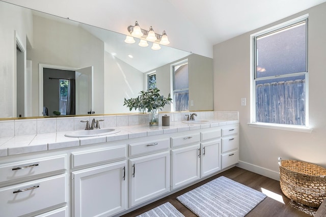 5642 W Beechwood Ave, Fresno, CA 93722 - full bath featuring double vanity, wood finished floors, lofted ceiling, and baseboards