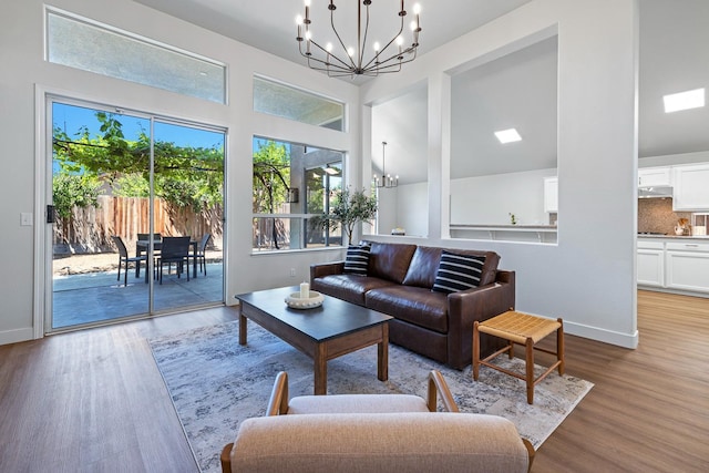 5642 W Beechwood Ave, Fresno, CA 93722 - living room with a chandelier, wood finished floors, baseboards, and a high ceiling