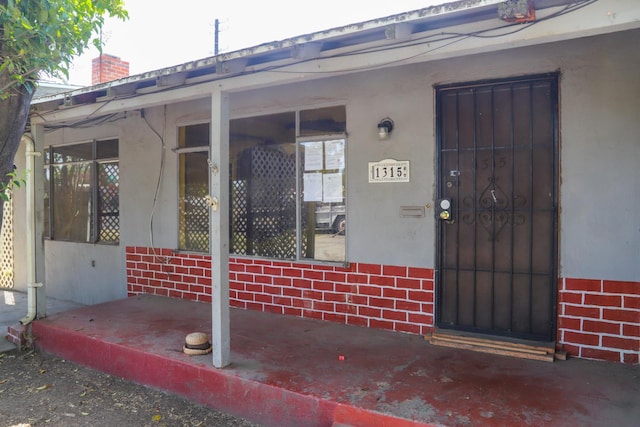 1315 W Fedora Ave, Fresno, CA 93705 - view of exterior entry with brick siding, a chimney, and stucco siding