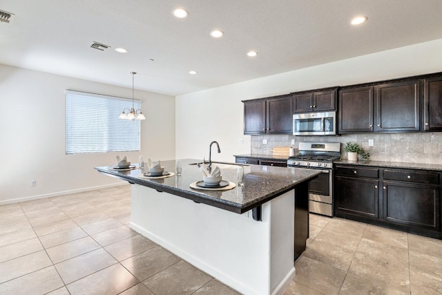 3834 Sussex Ave, Clovis, CA 93619 - kitchen featuring stainless steel appliances, decorative backsplash, dark stone countertops, a sink, and recessed lighting