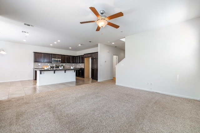 3834 Sussex Ave, Clovis, CA 93619 - unfurnished living room featuring a ceiling fan, baseboards, recessed lighting, light tile patterned floors, and light colored carpet