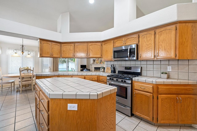 2903 Desert Ranch Way, Madera, CA 93637 - kitchen with stainless steel appliances, light tile patterned floors, brown cabinetry, tasteful backsplash, and a towering ceiling