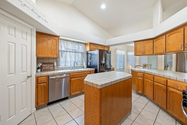 2903 Desert Ranch Way, Madera, CA 93637 - kitchen featuring stainless steel appliances, vaulted ceiling, tasteful backsplash, tile countertops, and light tile patterned flooring