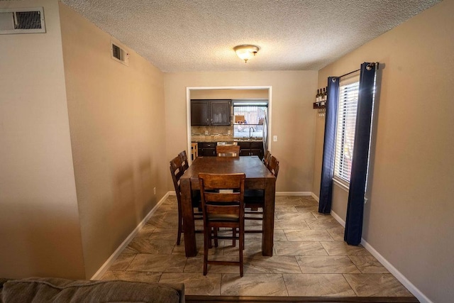 1603 E Serena Ave, Fresno, CA 93720 - dining room with a textured ceiling, baseboards, and light stone finish floors