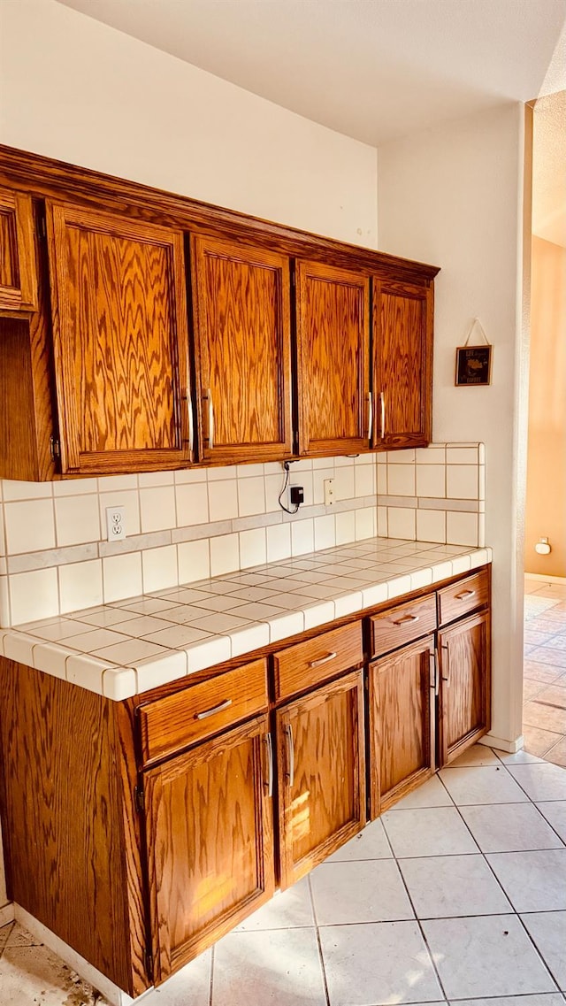5346 W Flint Way, Fresno, CA 93722 - kitchen with brown cabinets, tasteful backsplash, and light tile patterned flooring